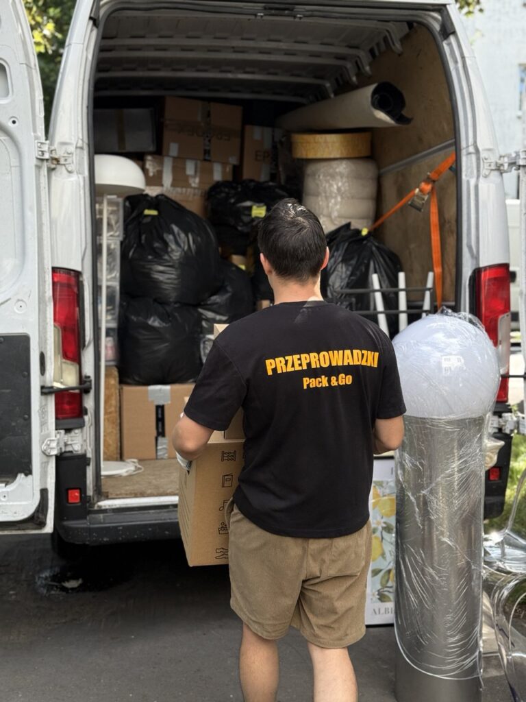 Pracownik ładuje karton do samochodu transportowego – przeprowadzki Warszawa