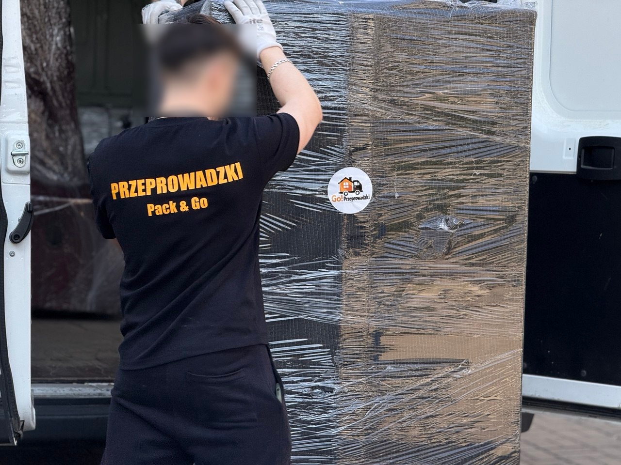 Zabezpieczona lodówka podczas załadunku do samochodu dostawczego – bezpieczny transport lodówki w Warszawie.