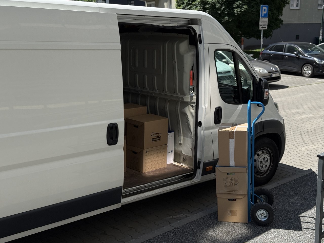 Załadunek mebli i kartonów do samochodu transportowego podczas przeprowadzki realizowanej przez Go Przeprowadzki.