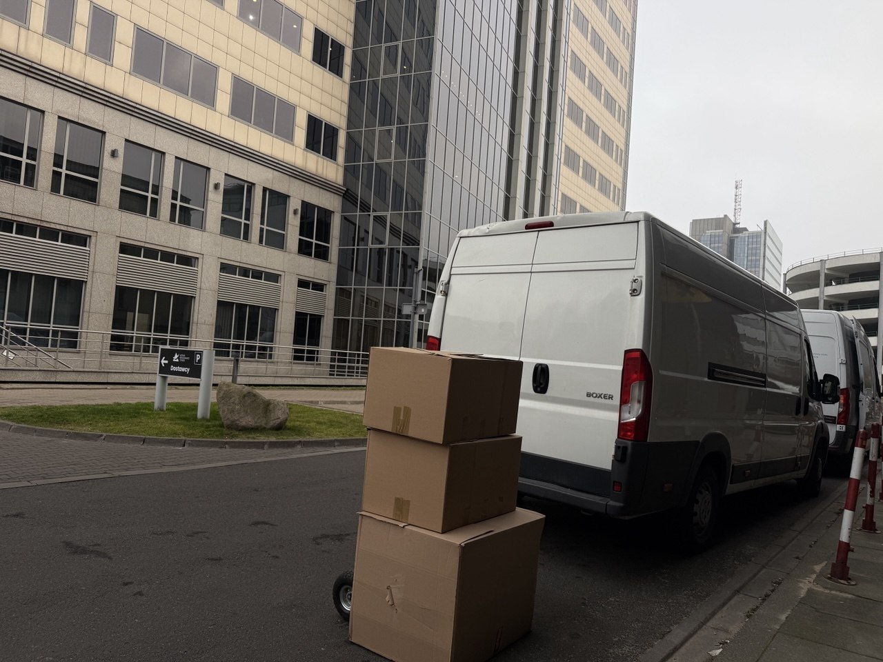 Taxi bagażowe Warszawa Go Przeprowadzki – biała furgonetka z kartonami podczas transportu w centrum miasta