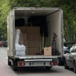 Auto dostawcze typu kontener firmy Go Przeprowadzki zaparkowane pod blokiem w Warszawie podczas profesjonalnej przeprowadzki.