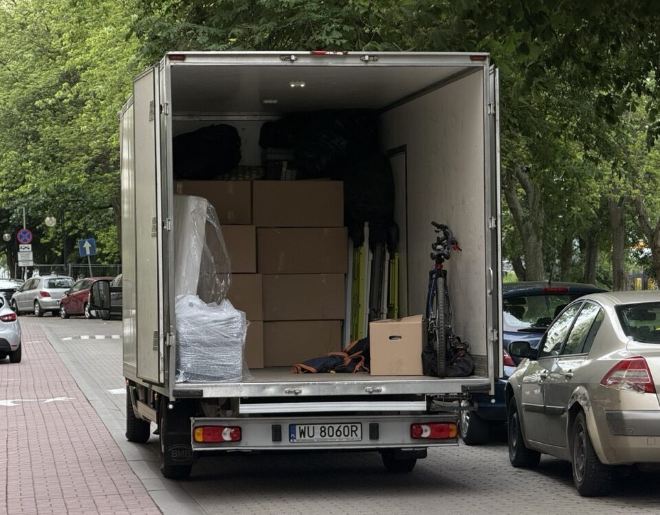 Auto dostawcze typu kontener firmy Go Przeprowadzki zaparkowane pod blokiem w Warszawie podczas profesjonalnej przeprowadzki.